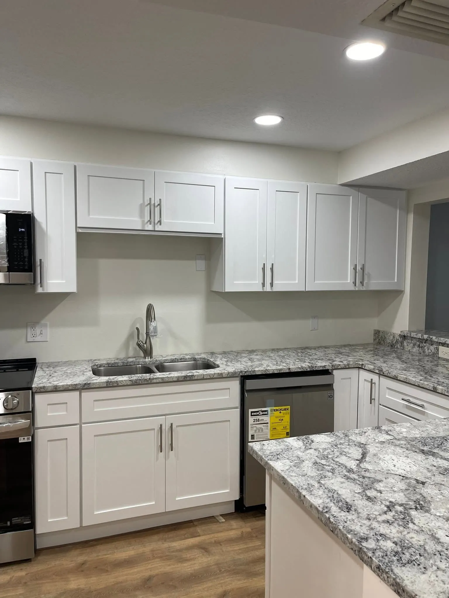 White shaker cabinets with a gray-veined granite countertop and an undermount sink
