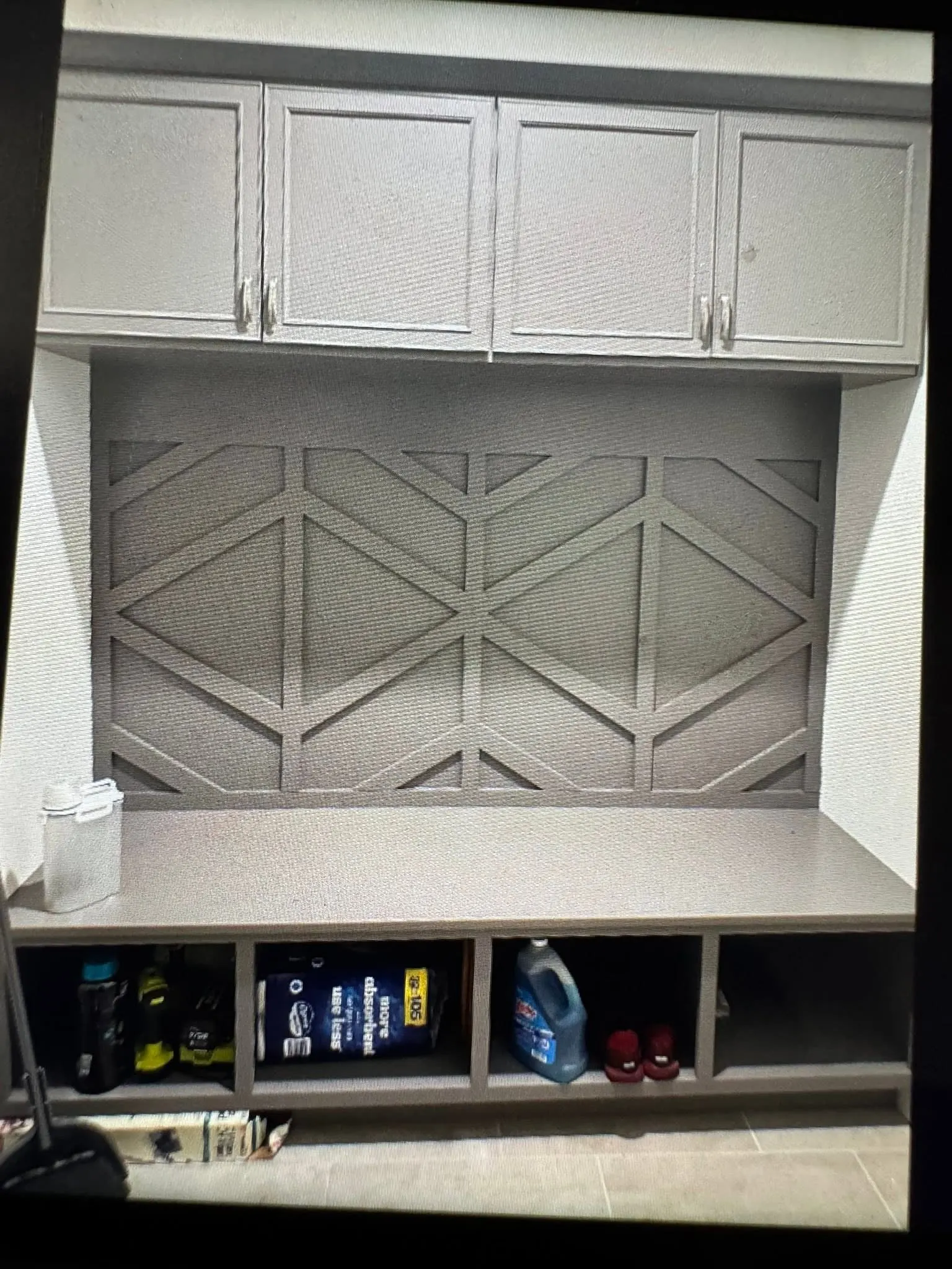 Mudroom built-in with white upper cabinets, a chevron-paneled back and open cubbies