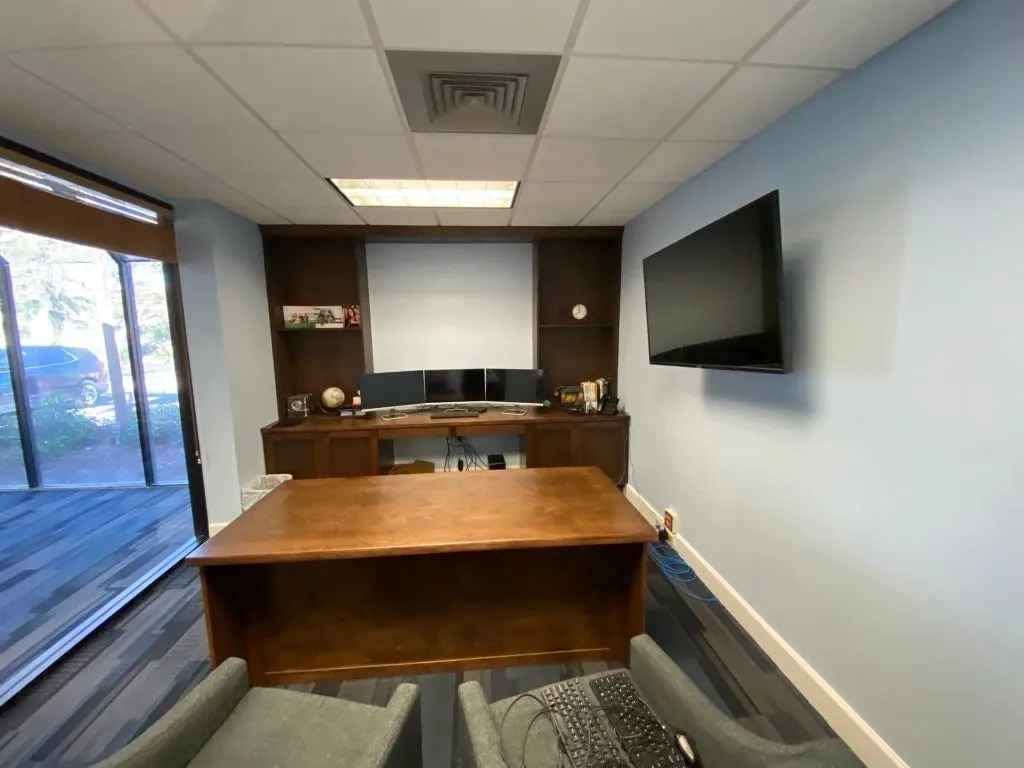 Office built-in wall and a large wood desk, seen from the doorway