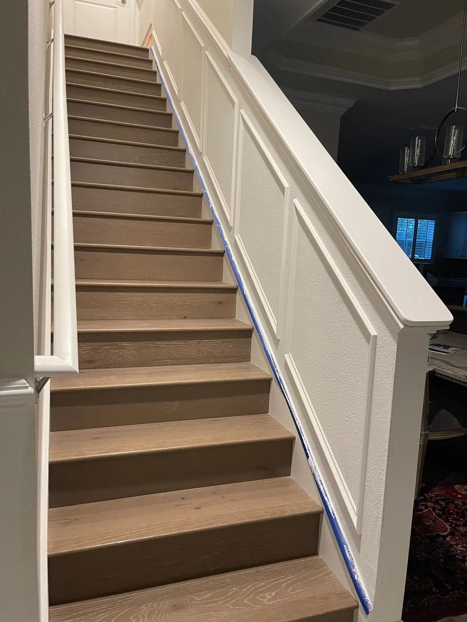 Staircase with a paneled knee wall and wainscoting