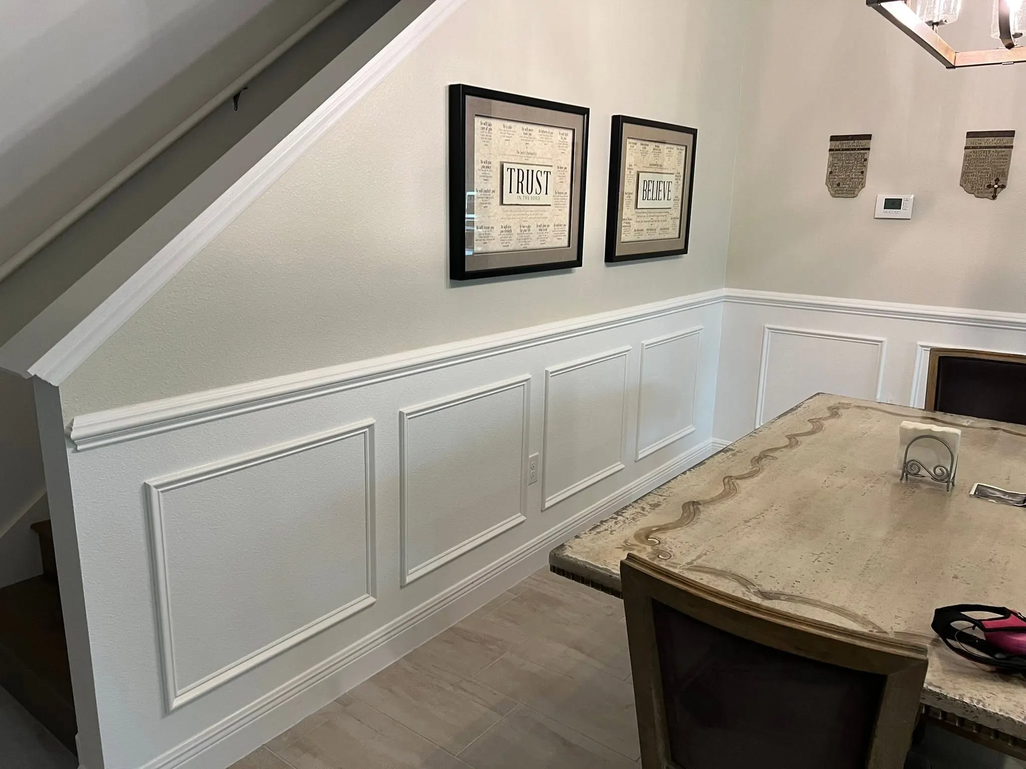 Wainscoting panels following the stair line beside a dining table